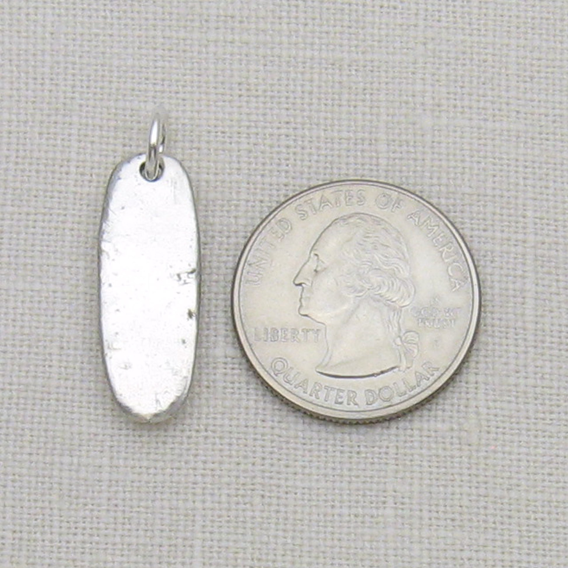 Silver Bar Cremation Ashes Pendant shown next to quarter for size reference