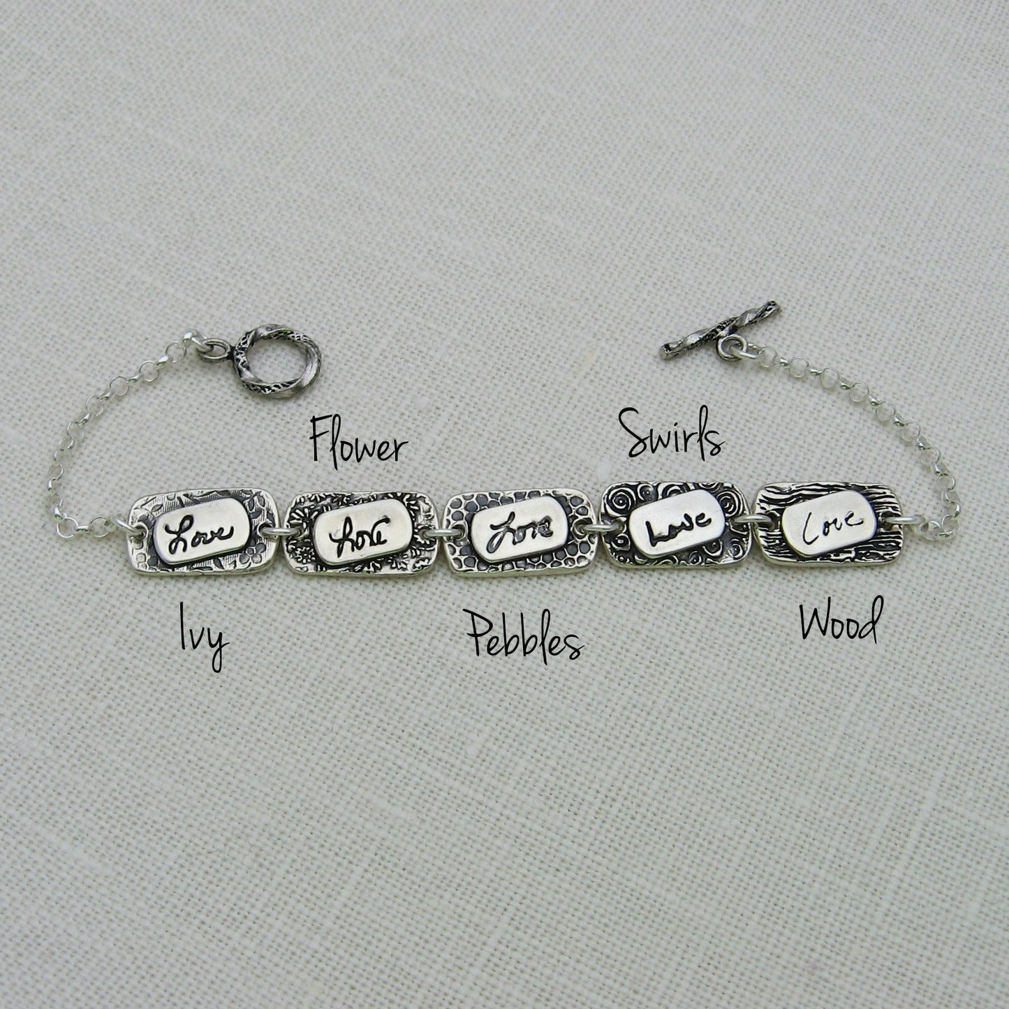 Sterling Silver Handwriting Layered Elements Link Bracelet Showing the 5 textures that are available: Ivy, Flower, Pebbles, Swirls, Wood