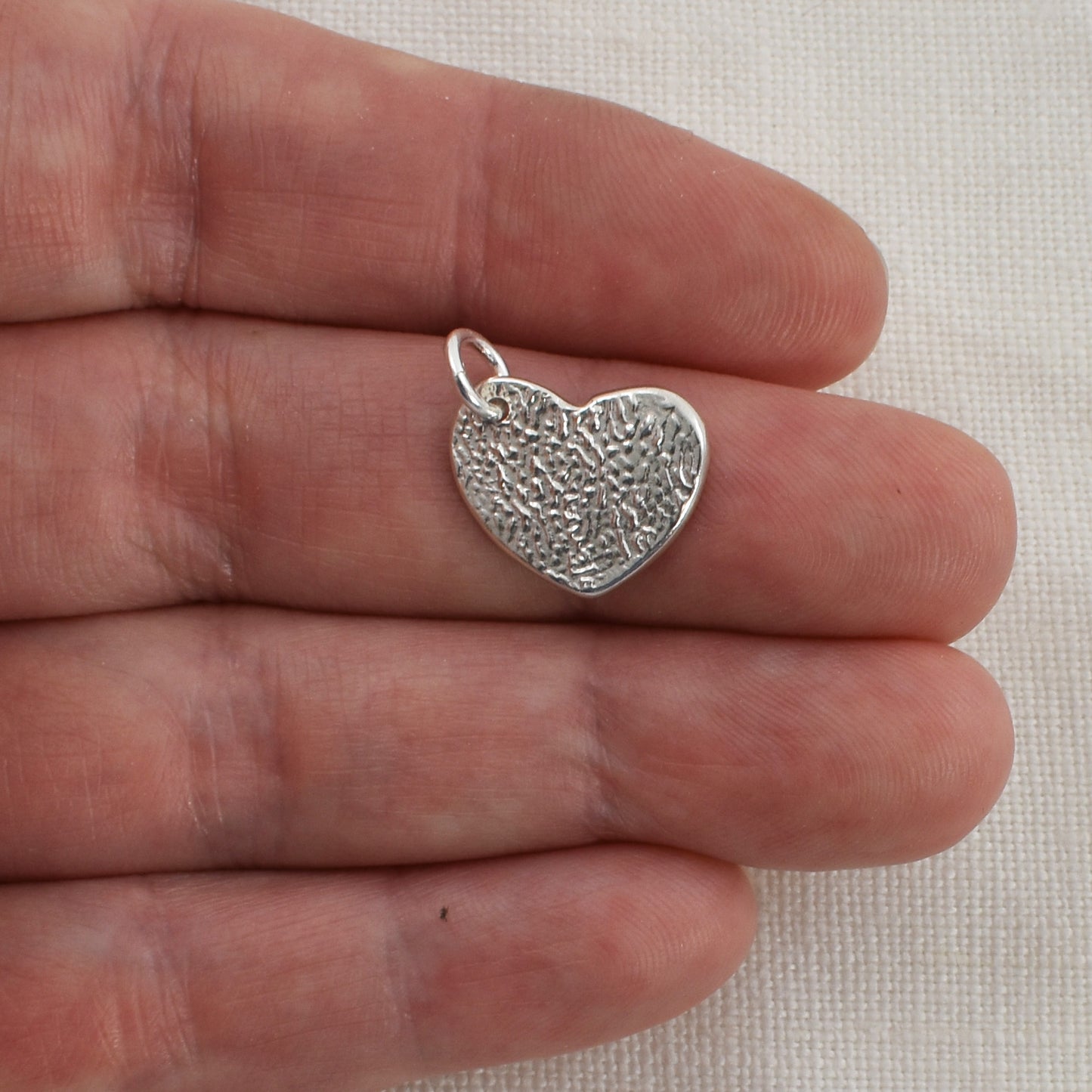 Cat Nose Textured Heart Pendant on Finger for Size Reference