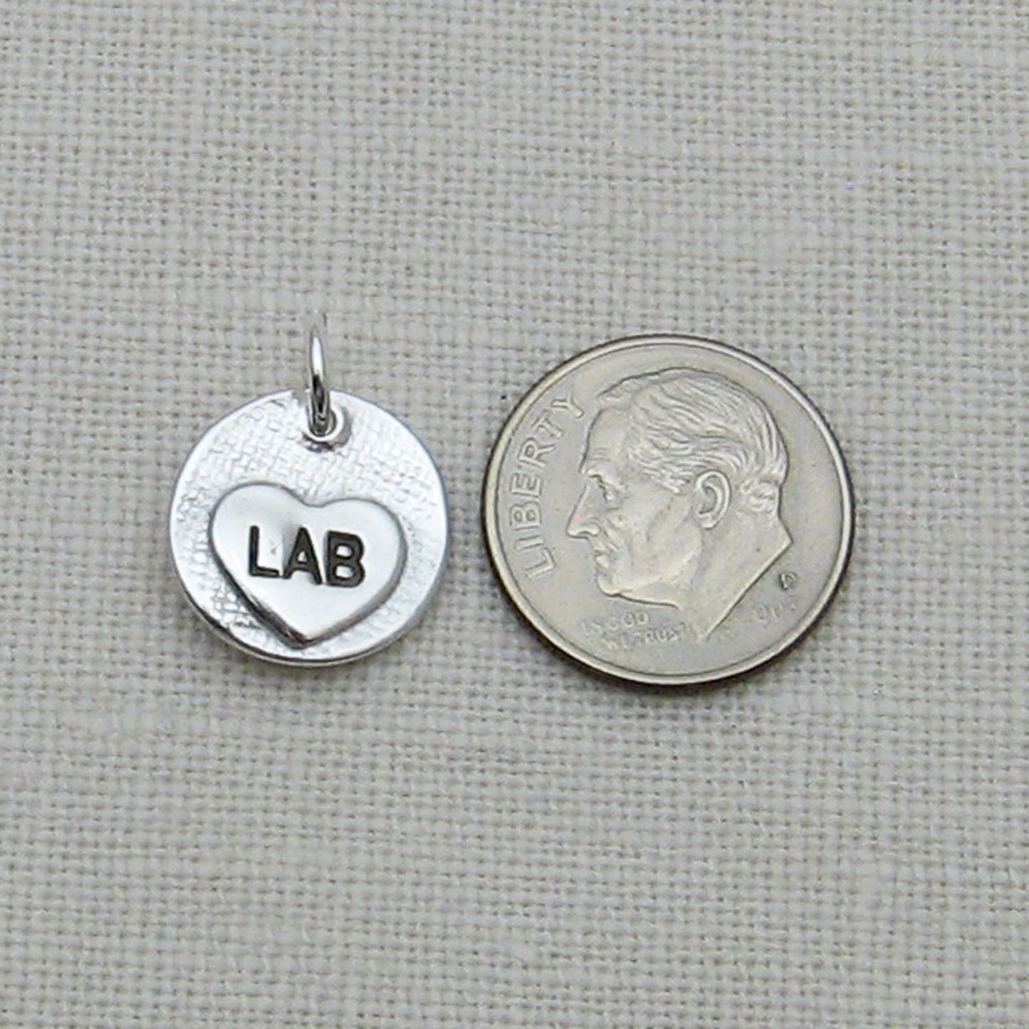 Back of Circle Pendant showing Small engraved heart next to dime for size reference