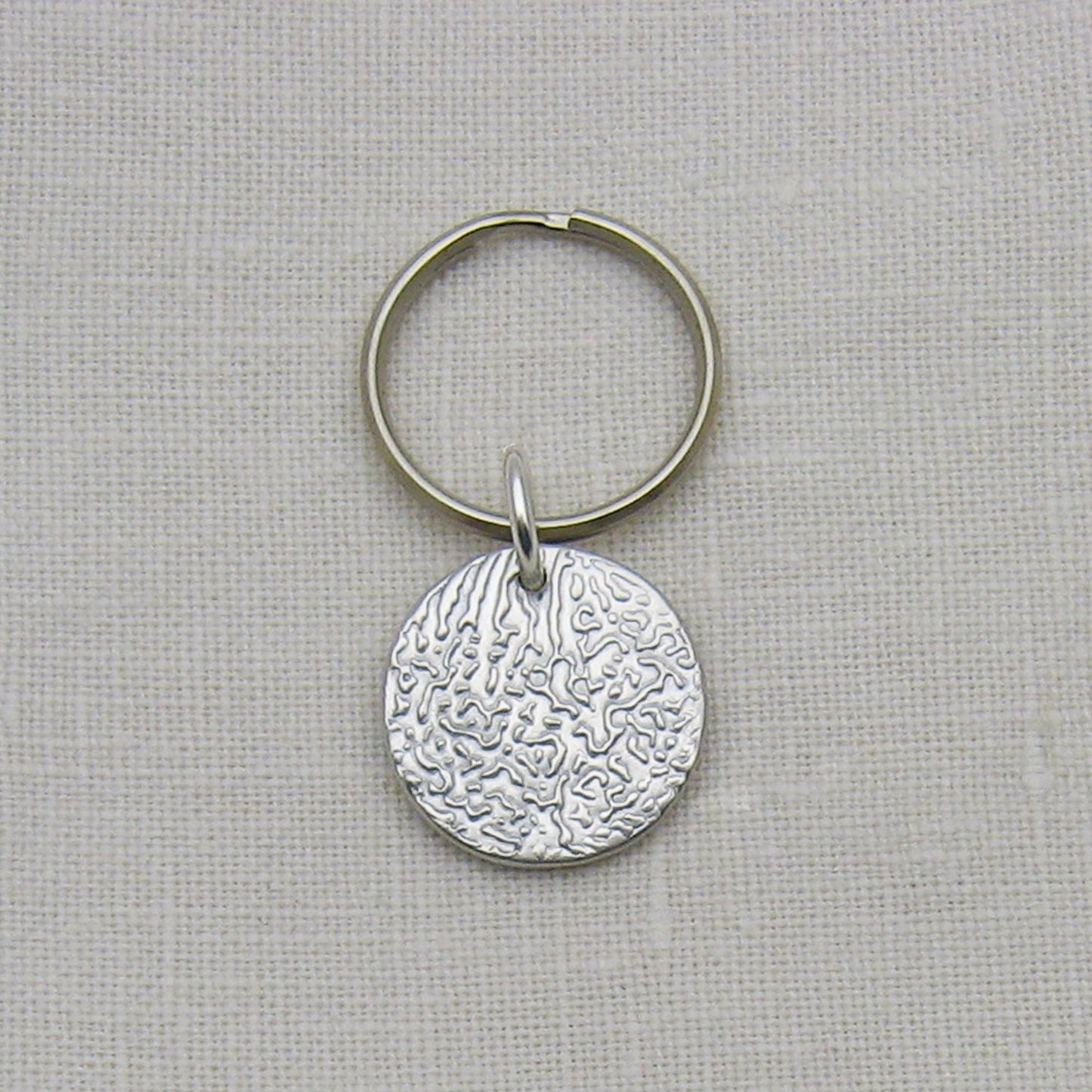 Dog Nose Textured Circle Keychain Shown as an example of textured pendant and all silver