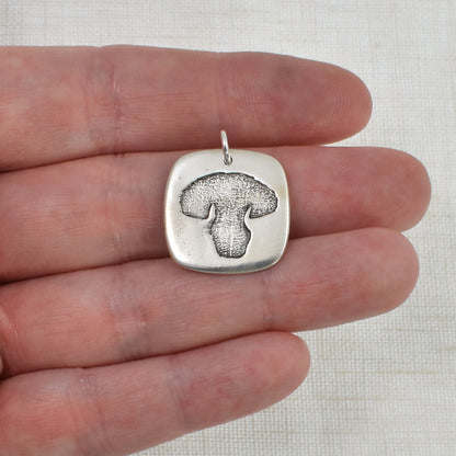 Dog Nose Rounded Square Pendant shown on hand for size reference