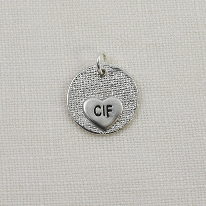 Back of circle with heart cutout fingerprint pendant showing small engraved heart