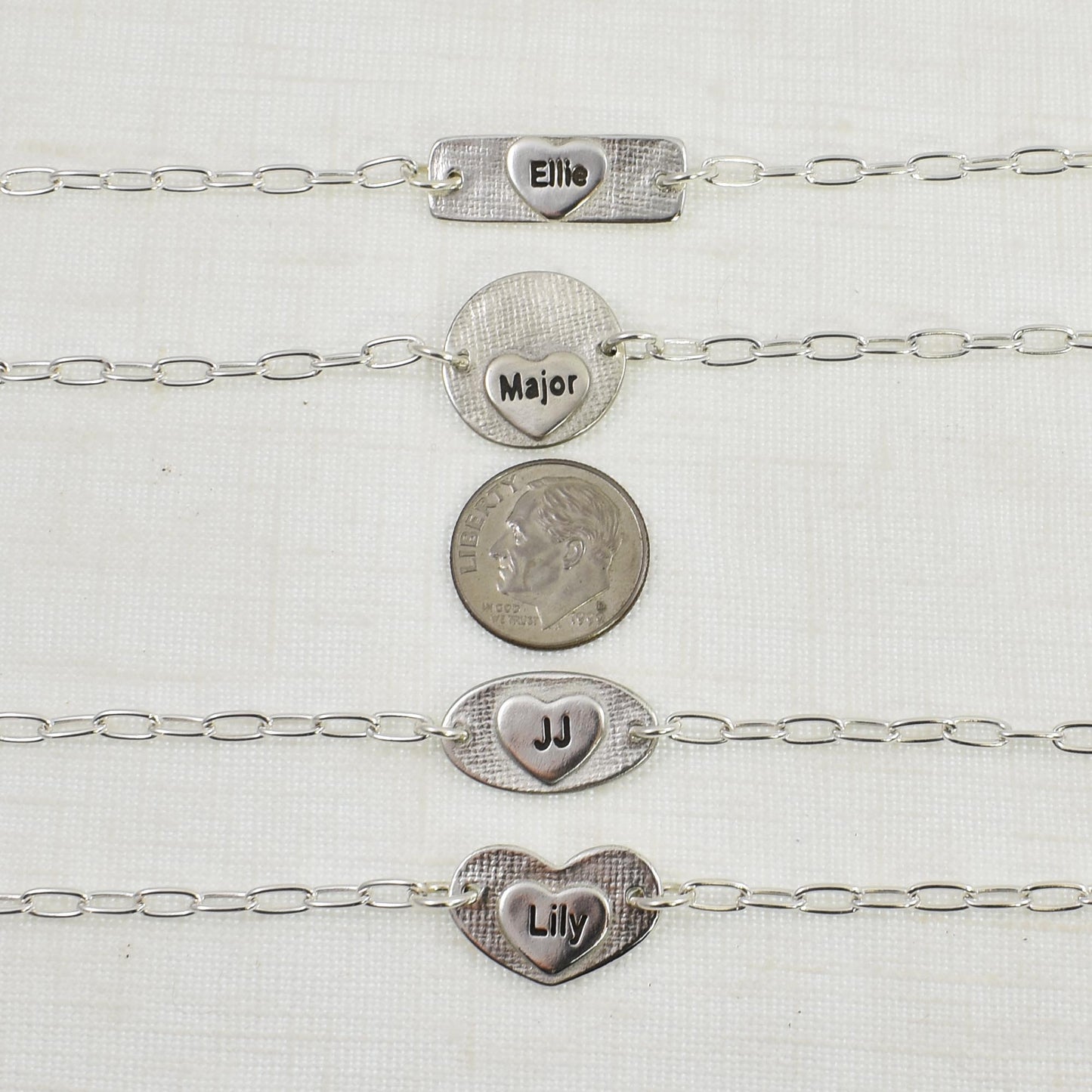 This photo shows the back of the Dog Nose Texture Bracelets with the small engraved heart.  They are also shown next to a United States nickel for size reference.  