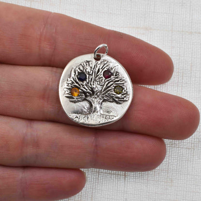 Silver Rustic Birthstone Tree Pendant shown on a hand for size reference
