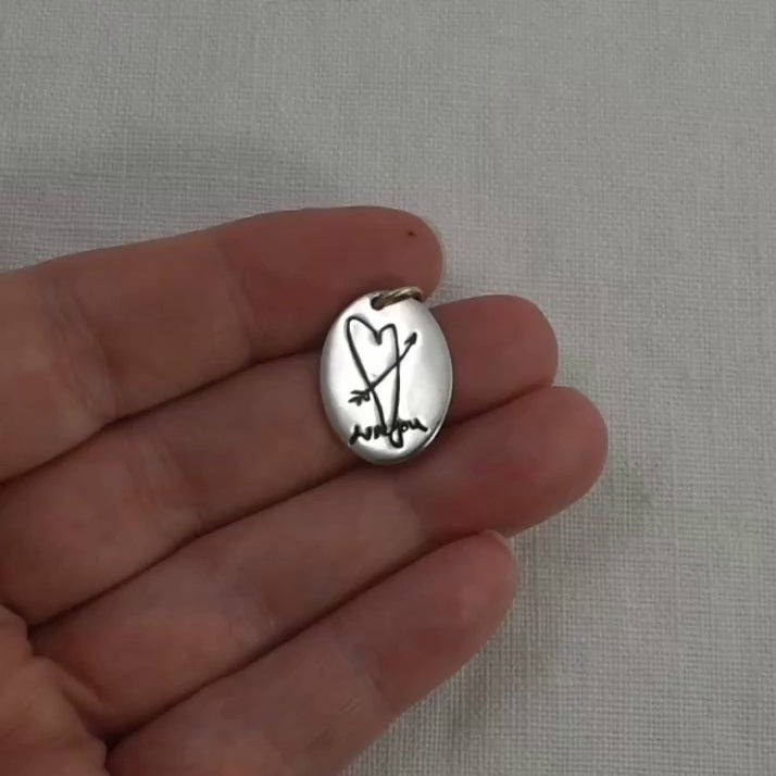 Video of a sterling silver oval pendant engraved with handwriting